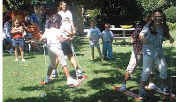 Kids playing games at a company picnic entertained by Charm and Happy clowns sent to the party.